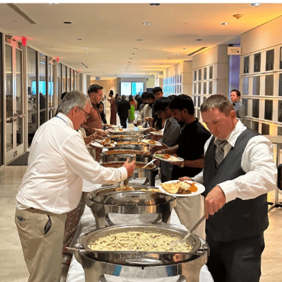 Guests serving themselves Indian cuisine from a buffet line at Rangoli Restaurant.