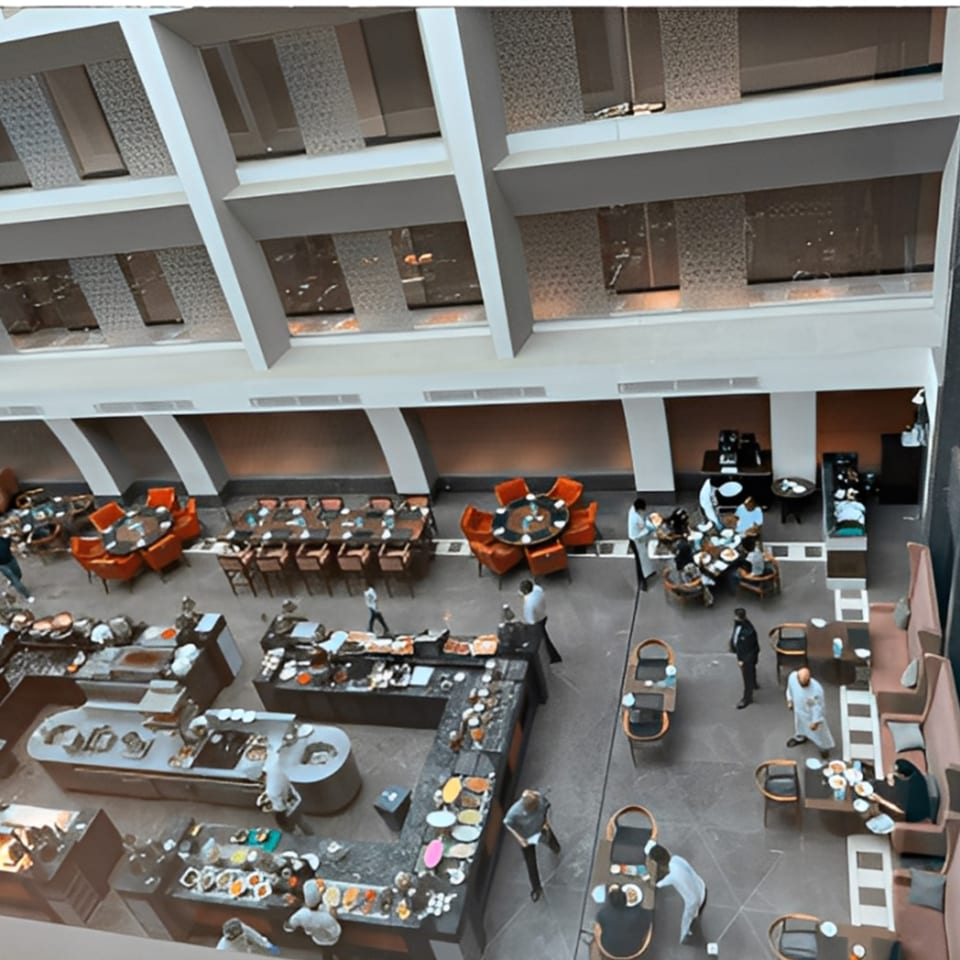 Overhead view of Rangoli Restaurant's spacious dining area with buffet stations and seated guests.